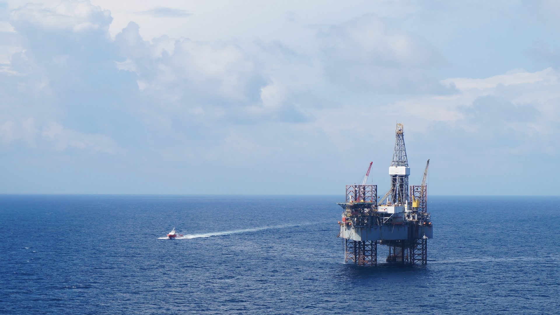 Jack Up Drilling Rig And Crew Boat In The Middle Of The Sea